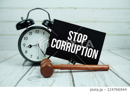 Stop Corruption text on paper card with alarm clock and wooden judge gavel on wooden background 124766944