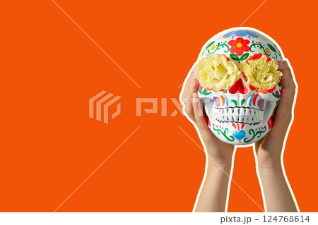 Cinco De Mayo, hands holding skull on orange background Cinco De Mayo, hands holding skull on orange background 124768614