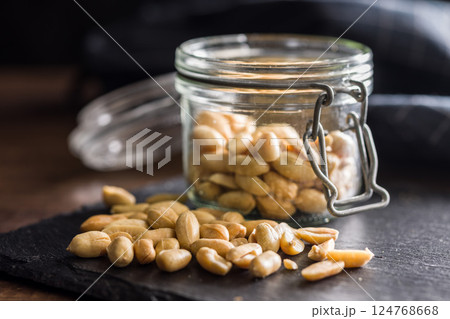 Roasted salted peanuts in jar on wooden table. Roasted salted peanuts in jar on wooden table. 124768668