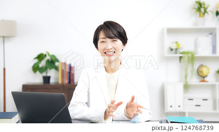 カメラ目線で会話する白衣のミドル女性 124768739