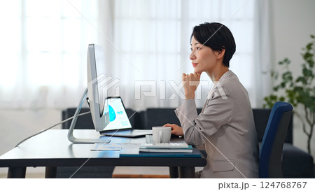 暗いオフィスでパソコンを使って作業する女性ビジネスパーソン 暗いオフィスでパソコンを使って作業する女性ビジネスパーソン 124768767