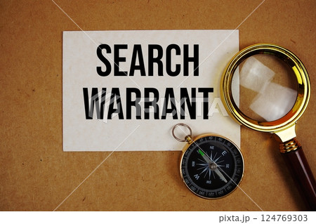 Search Warrant text on paper torn with compass and magnifying glass on paper craft background Search Warrant text on paper torn with compass and magnifying glass on paper craft background 124769303