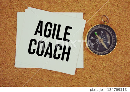 Agile Coach text on paper card with compass on cork paper background 124769318