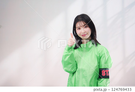 スタッフジャンパーをきた笑顔のイベントスタッフ(シンプル背景) スタッフジャンパーをきた笑顔のイベントスタッフ(シンプル背景) 124769433