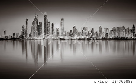 Urban city skyline with illuminated skyscrapers and waterfront railing in black and white at night, Dubai Marina bay UAE Urban city skyline with illuminated skyscrapers and waterfront railing in black and white at night, Dubai Marina bay UAE 124769888