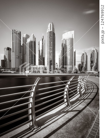 Skyscrapers and bridge over water, black and white style, city background, Dubai Marina bay UAE 124769912