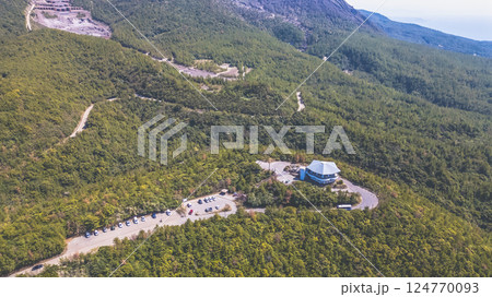 March 23 2025 View of a Lush Forest with Towering Mountain Peaks, Japan 124770093