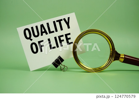 Quality Of Life text message on paper card with magnifying glass on green background 124770579