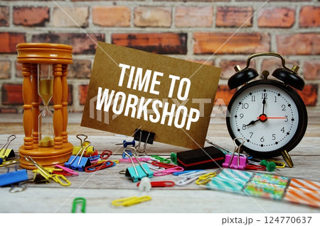 Time To Workshop text on paper card with alarm clock and stationary on wooden background Time To Workshop text on paper card with alarm clock and stationary on wooden background 124770637