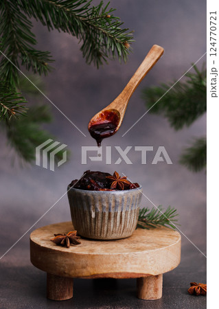 fresh organic berry and fruit jam with spices in a ceramic jar, with anise. wooden spoon with dripping jam over a cup. concept of homemade jam, preserves for winter, selective focus fresh organic berry and fruit jam with spices in a ceramic jar, with anise. wooden spoon with dripping jam over a cup. concept of homemade jam, preserves for winter, selective focus 124770721