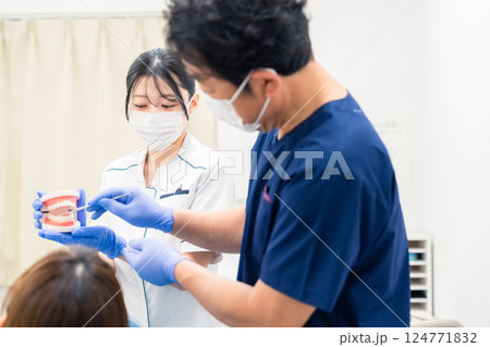 歯の模型を使って歯科治療の説明をする歯医者 歯の模型を使って歯科治療の説明をする歯医者 124771832