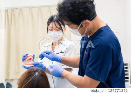 歯の模型を使って歯科治療の説明をする歯医者 歯の模型を使って歯科治療の説明をする歯医者 124771833
