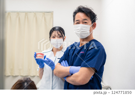 歯の模型を使って歯科治療の説明をする歯医者 歯の模型を使って歯科治療の説明をする歯医者 124771850