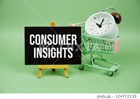 Consumer Insights text message on paper card with alarm clock and trolley shopping cart on green background Consumer Insights text message on paper card with alarm clock and trolley shopping cart on green background 124772139