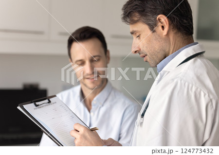 Doctor writing health complaints, patient information on clipboard Doctor writing health complaints, patient information on clipboard 124773432