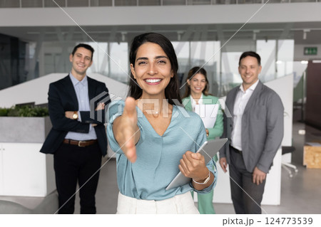 Happy Latin business leader woman offering handshake at camera Happy Latin business leader woman offering handshake at camera 124773539
