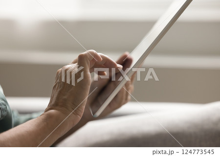 Close up cropped shot senior woman hands using digital tablet Close up cropped shot senior woman hands using digital tablet 124773545