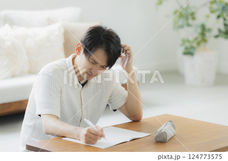リビングで勉強をする30代男性 124773575