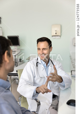 Doctor in white coat communicates with clinic patient Doctor in white coat communicates with clinic patient 124773588
