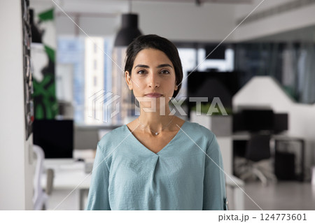 Confident beautiful young Latin businesswoman posing in office space Confident beautiful young Latin businesswoman posing in office space 124773601