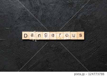 dangerous word written on wood block. dangerous text on cement table for your desing, concept 124773786