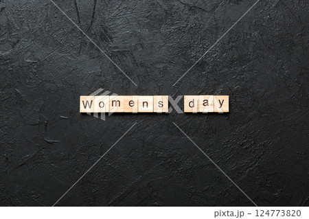 Womans day word written on wood block. Womans day text on cement table for your desing, concept Womans day word written on wood block. Womans day text on cement table for your desing, concept 124773820