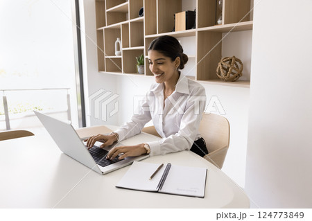 Indian woman, office employee or secretary working on laptop Indian woman, office employee or secretary working on laptop 124773849