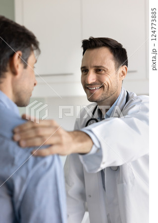 Physician in white coat speaking with sad male patient 124773885