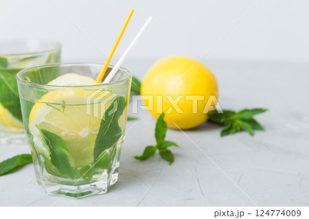 Mojito cocktail. Refreshing mojito cocktail with lime, lemon and mint in a tall glass with a stick 124774009