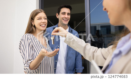 Happy couple receiving keys from their new house 124774083