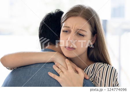 Closeup frowned woman hugs her partner, with emotions of sadness Closeup frowned woman hugs her partner, with emotions of sadness 124774096