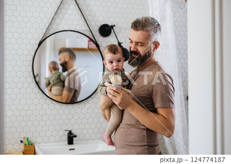 Portrait of father holding baby son in arms. Portrait of father holding baby son in arms. 124774187