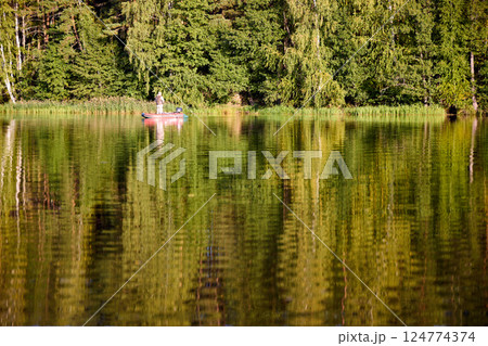 Fishing in a Boat on Calm Forest Lake 124774374