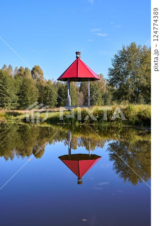 Tranquil Waterfront Gazebo on Sunny Day 124774389