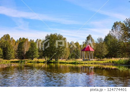 Tranquil Waterfront Gazebo on Sunny Day 124774401