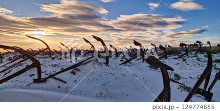 Rusty old anchors on the beach at the Anchor Cemetary graveyard at Praia do Barril beach in Tavira, Algarve, Portugal 124774885