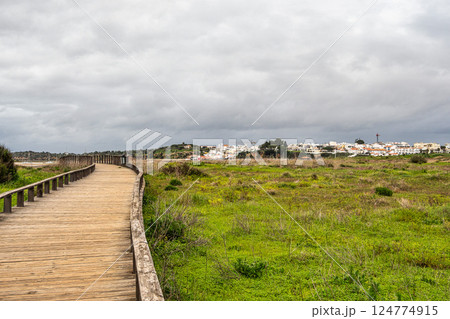 Wooden walkways lead to water in famous beach of Tres Irmaos in Alvor, Portimao, Algarve, Portugal, Europe Wooden walkways lead to water in famous beach of Tres Irmaos in Alvor, Portimao, Algarve, Portugal, Europe 124774915
