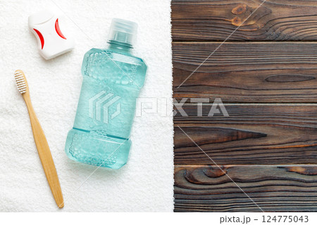 Mouthwash and other oral hygiene products on colored table top view with copy space. Flat lay. Dental hygiene. Oral care products and space for text on light background. concept Mouthwash and other oral hygiene products on colored table top view with copy space. Flat lay. Dental hygiene. Oral care products and space for text on light background. concept 124775043