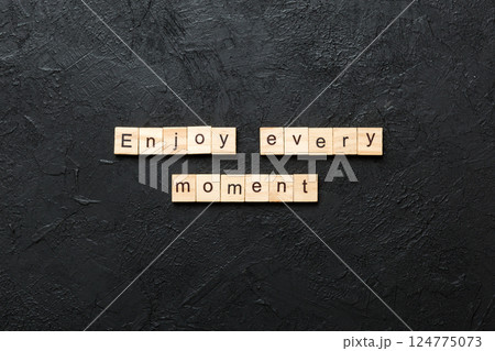 Enjoy Every Moment word written on wood block. Enjoy Every Moment text on cement table for your desing, concept 124775073