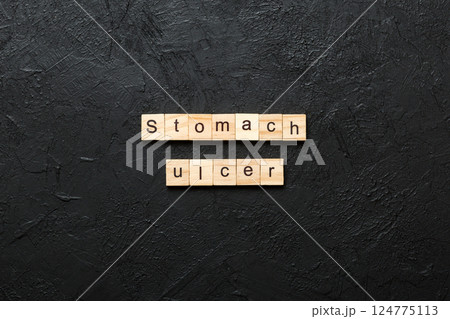 stomach ulcer word written on wood block. stomach ulcer text on table, concept 124775113
