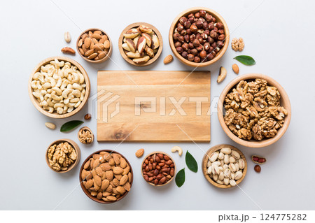 mixed nuts in wooden bowl. Mix of various nuts on colored background. pistachios, cashews, walnuts, hazelnuts, peanuts and brazil nuts mixed nuts in wooden bowl. Mix of various nuts on colored background. pistachios, cashews, walnuts, hazelnuts, peanuts and brazil nuts 124775282