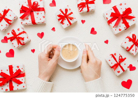 Flat lay of heart shaped cup of black coffee in the hands of women on colored background with copy space top view. Valentine day and holiday concept Flat lay of heart shaped cup of black coffee in the hands of women on colored background with copy space top view. Valentine day and holiday concept 124775350