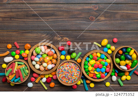 different colored round candy in bowl and jars. Top view of large variety sweets and candies with copy space 124775352