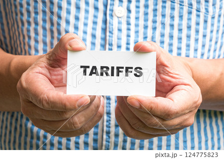 Man holding a white card with Tariffs message. 124775823