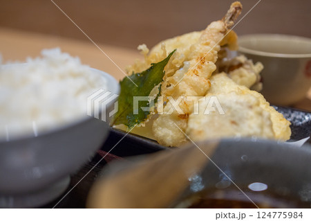 Japanese tempura set featuring crispy shrimp, vegetables, and a deep-fried leaf 124775984