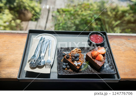 Chocolate cakes with blueberry and strawberry sauce in cafe 124776706