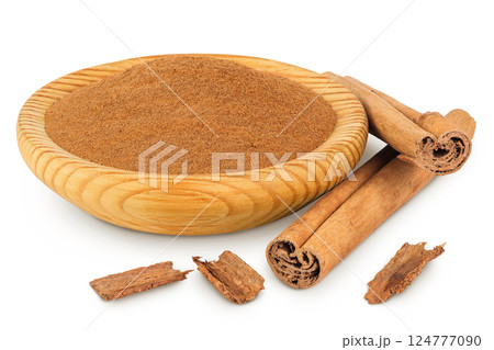 Cinnamon sticks with powder in wooden bowl isolated on white background with full depth of field 124777090