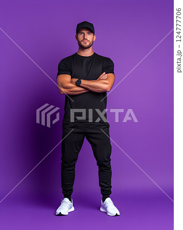 young athletic guy stands in sportswear with folded hands in full growth against bright background 124777706