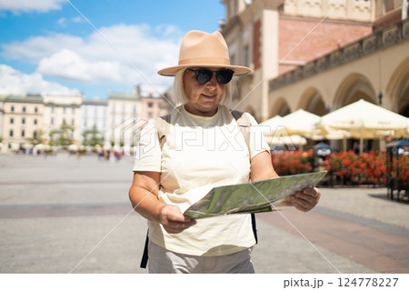 Senior woman exploring the city with a map, sightseeing in the square. Senior woman exploring the city with a map, sightseeing in the square. 124778227