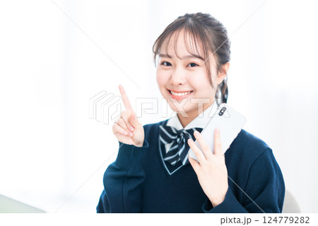 スマホを握りしめてポーズをとる女子高生 スマホを握りしめてポーズをとる女子高生 124779282